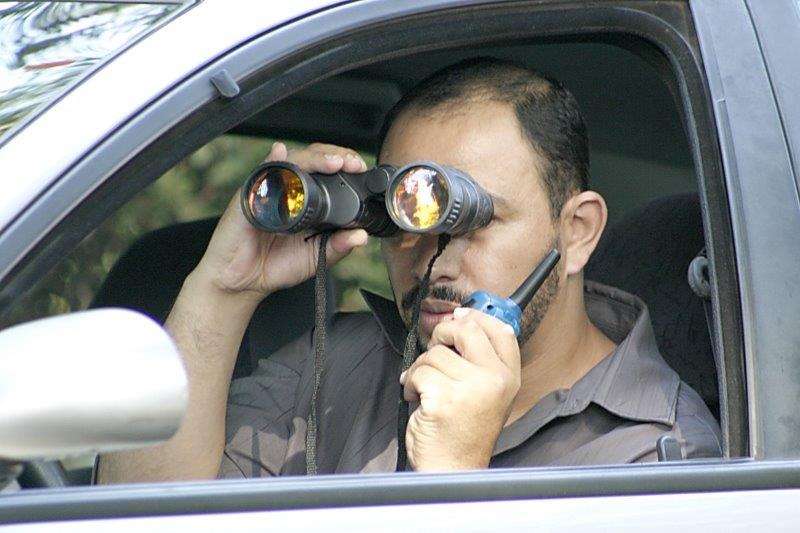 Investigador em operação de campo com binóculos